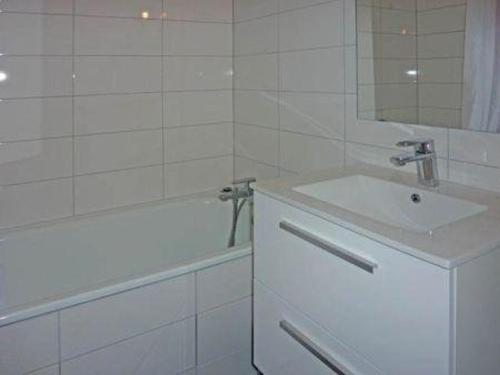 ein Badezimmer mit einem Waschbecken, einer Badewanne und einem Spiegel in der Unterkunft Studio Les Orres, 1 pièce, 4 personnes - FR-1-322-115 in Les Orres