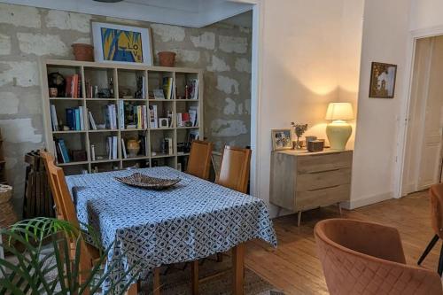 une salle à manger avec une table et une étagère à livres dans l'établissement Appartement d'exception au cœur de Bordeaux, à Bordeaux