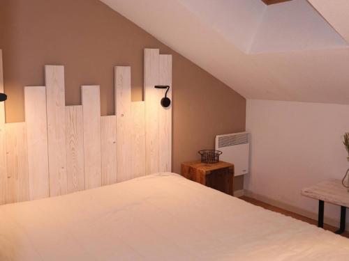 a bedroom with a bed with a wooden wall at Appartement Les Orres, 2 pièces, 4 personnes - FR-1-322-38 in Les Orres