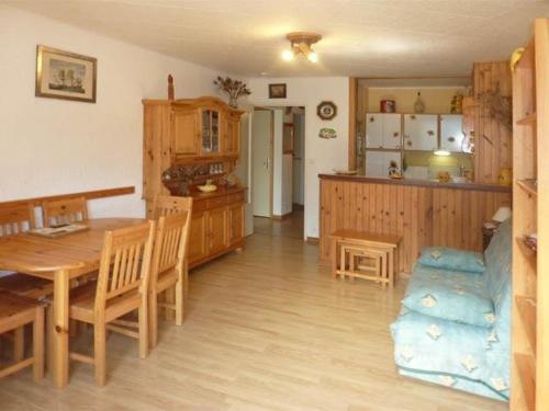 une cuisine et une salle à manger avec une table et des chaises en bois dans l'établissement Appartement 8 pers, coeur station, pieds des pistes - FR-1-322-41, aux Orres