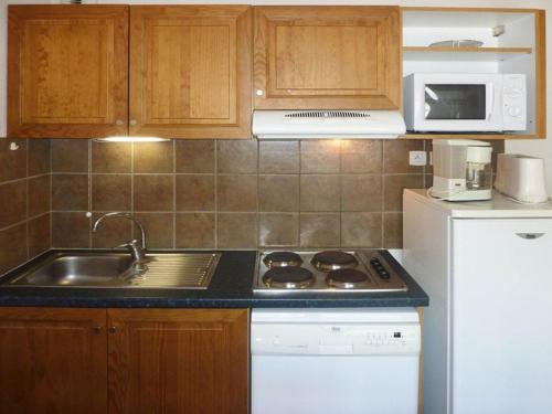 La cuisine est équipée d'un évier, d'une cuisinière et d'un réfrigérateur. dans l'établissement Superbe duplex 10 pers avec piscine et jacuzzi aux Orres 1800 - FR-1-322-206, aux Orres