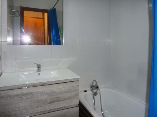 une personne prenant une photo d'une salle de bains avec baignoire et lavabo dans l'établissement Studio central 4/6 pers, accès pistes, balcon, animaux admis - FR-1-322-59, aux Orres