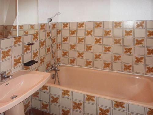une salle de bain avec une baignoire et un lavabo dans l'établissement Appt skis aux pieds avec parking, balcon, 4 lits, animaux acceptés - FR-1-322-154, aux Orres