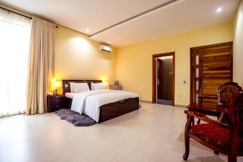 a bedroom with a bed and a desk and a chair at Rushmore - Luxury Suite in Lagos