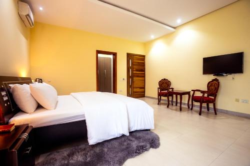 a bedroom with a bed and a flat screen tv at Rushmore - Luxury Suite in Lagos