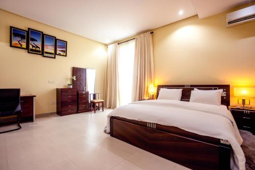 a large bedroom with a large bed and a chair at Rushmore - Luxury Suite in Lagos