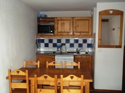 une cuisine avec une table en bois et une table et des chaises dans l'établissement Appartement 3 pièces 6 pers, proche pistes, parking, casier à skis, cuisine équipée - FR-1-262-145, à Les Estaris