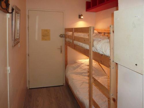 - deux lits superposés dans une chambre avec une porte dans l'établissement Appartement cosy, skis aux pieds, proche centre station, balcon sud, 6 pers. - FR-1-322-197, aux Orres