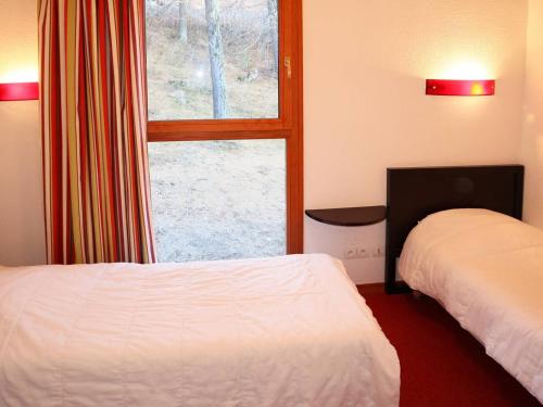 レ・ゾルにあるChalet Les Orres, 3 pièces, 6 personnes - FR-1-322-108のベッド2台と窓が備わるホテルルームです。
