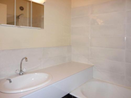 a white bathroom with a sink and a tub at Appartement Les Orres, 2 pièces, 6 personnes - FR-1-322-276 in Les Orres