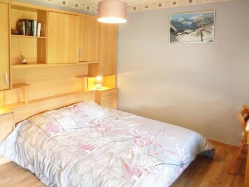 a bedroom with a white bed with flowers on it at Appartement Les Orres, 2 pièces, 6 personnes - FR-1-322-199 in Les Orres
