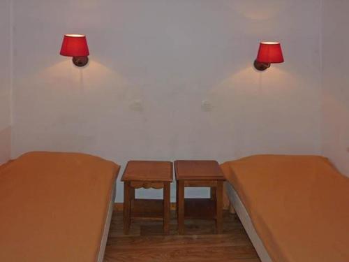 レ・ゾルにあるStudio Les Orres, 1 pièce, 4 personnes - FR-1-322-125のベッド2台、テーブル、ランプが備わる客室です。