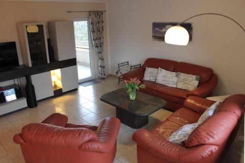 a living room with leather couches and a coffee table at Grosszuegige-Ferienwohnung-im-OT-Bad-Strandnaehe in Sankt Peter-Ording