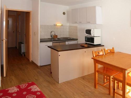 une petite cuisine avec une table et un micro-ondes dans l'établissement Studio confortable pour 4 pers., skis aux pieds, animaux admis - FR-1-322-151, aux Orres