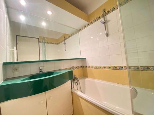 y baño con bañera, lavabo y espejo. en Appartement La Baule, 2 pièces, 3 personnes - FR-1-245-34, en La Baule