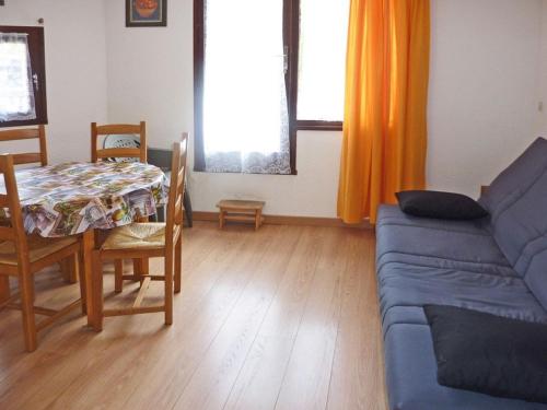 un salon avec un canapé bleu et une table dans l'établissement Studio cosy 4 personnes au pied des pistes avec terrasse - FR-1-322-177, aux Orres