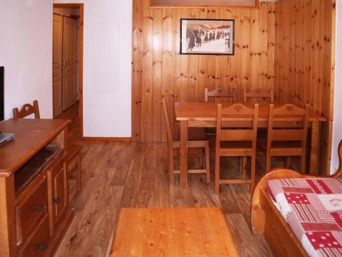 une salle à manger avec une table et des chaises en bois dans l'établissement Appartement de standing avec piscine chauffée, sauna et accès skis aux pieds - FR-1-322-184, aux Orres