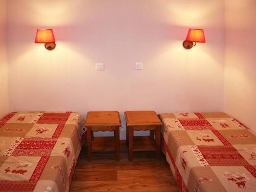 Cette chambre comprend 2 lits jumeaux et 2 tables. dans l'établissement Appartement de standing avec piscine chauffée, sauna et accès skis aux pieds - FR-1-322-184, aux Orres