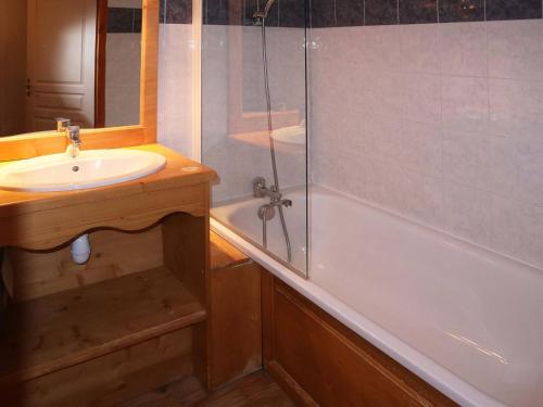 une salle de bain avec un lavabo et une douche en verre dans l'établissement Appartement de standing avec piscine chauffée, sauna et accès skis aux pieds - FR-1-322-184, aux Orres
