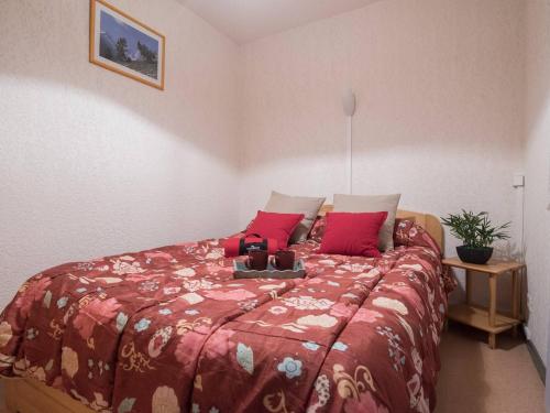 une chambre avec un grand lit avec des oreillers rouges dans l'établissement Appartement calme, proche centre Saint-Lary Soulan, 6 pers, terrasse, parking, navette gratuite - FR-1-296-172, à Saint-Lary-Soulan