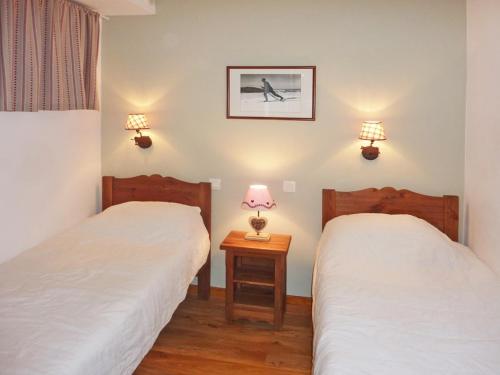 - 2 lits dans une chambre avec 2 lampes sur le mur dans l'établissement Appartement 8 pers avec piscine chauffée et sauna, balcon exposé Ouest, Orres 1800 - FR-1-322-202, aux Orres