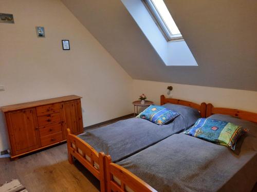 two twin beds in a bedroom with a skylight at Nosztalgia Vendégház in Bogács
