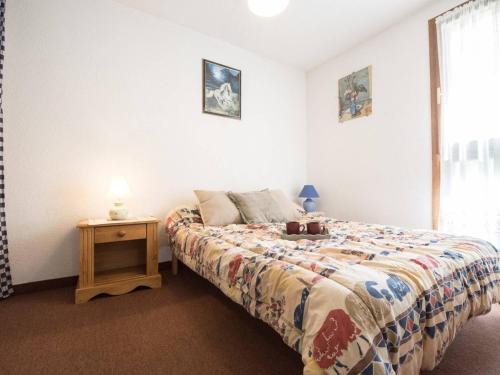 une chambre avec un lit et une table avec une lampe dans l'établissement Appartement cosy pour 6 pers. avec balcon, proche centre et téléphérique, Saint Lary Village - FR-1-296-207, à Saint-Lary-Soulan