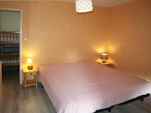 萊索爾的住宿－Appartement Les Orres, 2 pièces, 6 personnes - FR-1-322-232，一间卧室配有一张大床和两张带台灯的桌子。