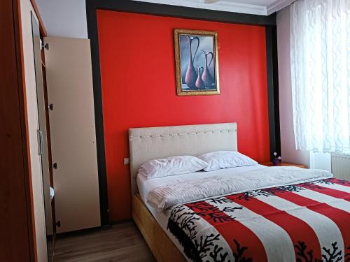 een slaapkamer met een rode muur en een bed bij The City Residence Hotel in Canakkale