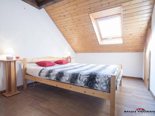 une chambre avec un lit avec un plafond en bois dans l'établissement Appartement pour 6 pers. avec balcon près de Saint-Lary, Wi-Fi et parking gratuits - FR-1-296-215, à Saint-Lary-Soulan