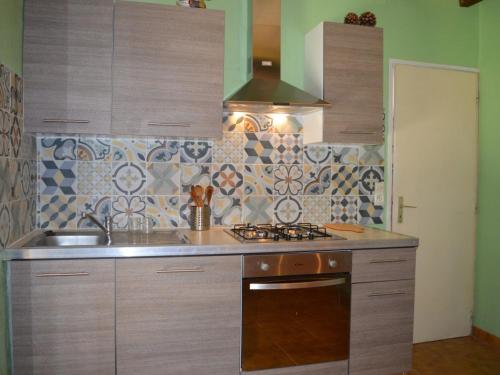 uma cozinha com um lavatório e um fogão forno superior em Maison Saint-Cyprien, 4 pièces, 7 personnes - FR-1-225D-421 em Saint-Cyprien-Plage
