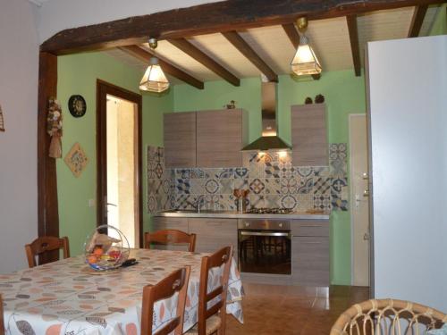 une salle à manger avec une table et une cuisine dans l'établissement Charmante Villa à 1km de la Plage, 7 couchages, Garage, Jardin Privé, St-Cyprien - FR-1-225D-421, à Saint Cyprien Plage