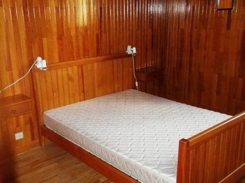 Una cama en una habitación con paredes revestidas de madera. en Appartement 3 pièces, 8 pers - Proche commerces et pistes à Orcières Merlette - FR-1-262-147, en Les Estaris