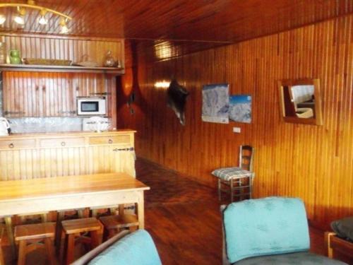 - une cuisine avec des murs en bois, une table et des chaises dans l'établissement Appartement 3 pièces, 8 pers - Proche commerces et pistes à Orcières Merlette - FR-1-262-147, à Les Estaris
