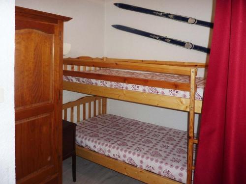 レ・ゾルにあるAppartement Les Orres, 2 pièces, 5 personnes - FR-1-322-280の壁にスキー用具が備わる客室で、二段ベッド2組が備わります。
