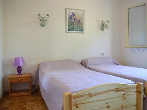 1 dormitorio con 2 camas y mesa con lámpara en Maison Argelès-sur-Mer, 5 pièces, 7 personnes - FR-1-225-460, en Argelès-sur-Mer
