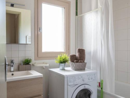 une salle de bain avec une machine à laver et un lavabo dans l'établissement Charmant T2 avec Balcon et Parking Privé - Proche Centre et Téléphérique - FR-1-296-138, à Saint-Lary-Soulan