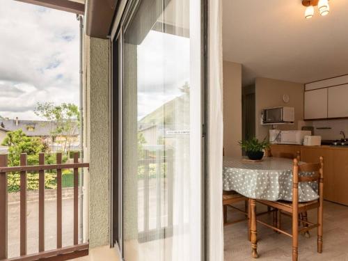 une porte coulissante en verre menant à un balcon avec une table. dans l'établissement Appartement Saint-Lary-Soulan, 2 pièces, 4 personnes - FR-1-296-138, à Saint-Lary-Soulan