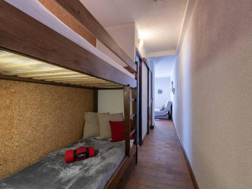 - une chambre avec 2 lits superposés et une valise rouge dans l'établissement Appartement confort près centre et téléphérique, balcon, parking, idéal famille - FR-1-296-127, à Saint-Lary-Soulan
