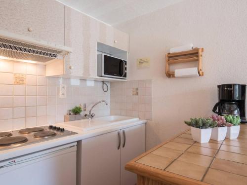 une petite cuisine avec un évier et un micro-ondes dans l'établissement Appartement calme avec balcon, 6 personnes, centre Saint-Lary Soulan, proche remontées et parking privé - FR-1-296-155, à Saint-Lary-Soulan