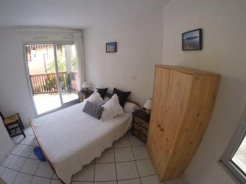 een slaapkamer met een groot bed en een raam bij Appartement T2 cabine avec terrasse et piscine à Vieux-Boucau, idéal pour les vacances ! - FR-1-379-18 in Vieux-Boucau-les-Bains