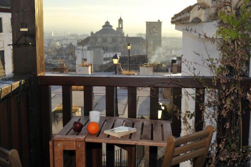 a table on a balcony with a view of a city at Smart Suites Albaicin in Granada