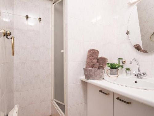 une salle de bain blanche avec un lavabo et une douche dans l'établissement Appartement ensoleillé pour 4 pers, balcon, parking, proche thermes et téléphérique, St-Lary Village - FR-1-296-195, à Saint-Lary-Soulan