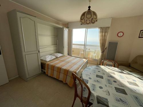 une chambre avec deux lits et une table et une fenêtre dans l'établissement Studio 2 pers, balcon, parking, plage à 200m - FR-1-224C-442, à Saint-Jean-de-Monts