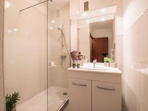 ein weißes Badezimmer mit Waschbecken und Dusche in der Unterkunft Appartement 4 pers avec terrasse, parking privé, proche thermes et remontées mécaniques - FR-1-296-198 in Saint-Lary-Soulan