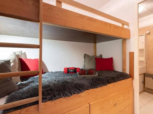 1 Schlafzimmer mit 2 Etagenbetten mit roten Kissen in der Unterkunft Agréable studio cabine 4 pers avec parking à Saint-Lary village - FR-1-296-218 in Saint-Lary-Soulan