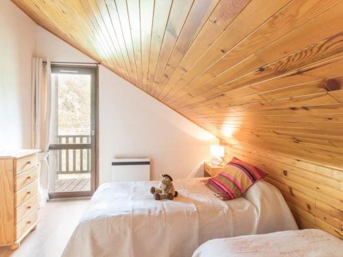 un osito de peluche sentado en una cama en un dormitorio en Appartement Le Monêtier-les-Bains, 3 pièces, 6 personnes - FR-1-330F-27, en Le Monêtier-les-Bains