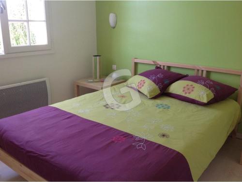 - une chambre avec un lit doté de draps et d'oreillers violets dans l'établissement Maison familiale proche plage avec jardin et parking à Saint-Vincent-sur-Jard - FR-1-357-32, à Saint-Vincent-sur-Jard