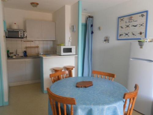 une cuisine avec une table et des chaises ainsi qu'une cuisine avec une table et une table dans l'établissement Appartement T2 Cabine au bord du lac, 6 pers, animaux admis - FR-1-379-24, à Vieux-Boucau-les-Bains