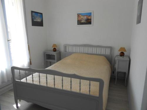 een slaapkamer met een bed met 2 tafels en 2 lampen bij Appartement Vieux-Boucau-les-Bains, 2 pièces, 5 personnes - FR-1-379-24 in Vieux-Boucau-les-Bains